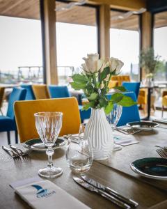 une table avec un vase blanc et des roses dans l'établissement Varbla sadam ja restoran Groot, 