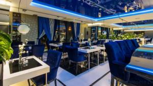 a restaurant with blue chairs and tables at Luxury Apartments Seveeu in Warsaw