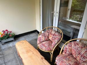 un par de sillas y una mesa en un porche en One Queens Gardens, Sea View Apartment, Eastbourne., en Eastbourne
