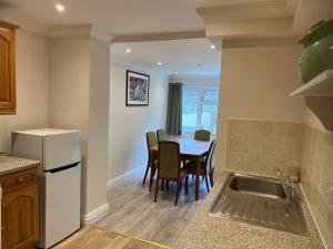 uma cozinha e sala de jantar com mesa e cadeiras em One Queens Gardens, Sea View Apartment, Eastbourne. em Eastbourne