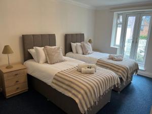 1 dormitorio con 2 camas con animales de peluche en One Queens Gardens, Sea View Apartment, Eastbourne., en Eastbourne