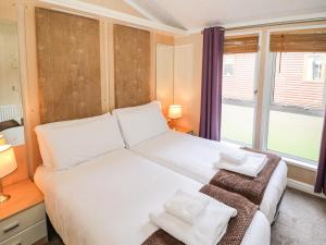 Un dormitorio con una cama blanca grande y una ventana en Daisy, en Leominster