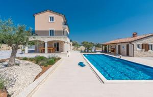 a villa with a swimming pool and a house at Stone Luxury Villa in Gajana