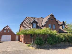 a large brick house with a garage at 108 qm EG-Fewo mit Garten - Grill - Westterrassen in Oevenum