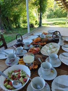 una mesa de madera con platos de comida. en Country House Uliana, en Tskaltubo