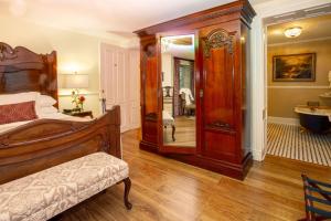 sypialnia z łóżkiem i dużym lustrem w obiekcie Kehoe House, Historic Inns of Savannah Collection w mieście Savannah