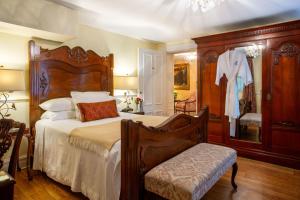 a bedroom with a large bed and a chair at Kehoe House, Historic Inns of Savannah Collection in Savannah