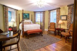 a bedroom with a bed and a table and chairs at Kehoe House, Historic Inns of Savannah Collection in Savannah