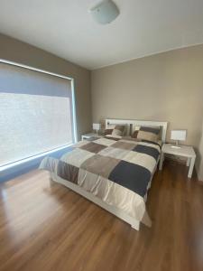 a bedroom with a large bed and a large window at Holiday HOUSE Vecāķi in Rīga
