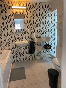a bathroom with a black and white patterned wall at Holiday HOUSE Vecāķi in Riga