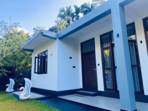 a house with a blue and white facade at Thanu Villa in Unawatuna