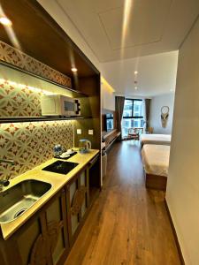 - une cuisine avec évier et un lit dans une chambre dans l'établissement Apec Mandala Mui Ne Phan Thiet R2223, à Ấp Thiẹn Ái