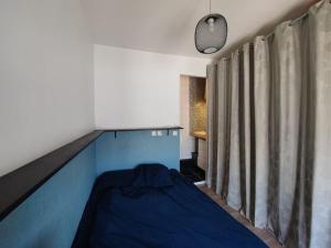 een slaapkamer met een blauw bed in een kamer bij 2 pièces Lumineux & Calme (28m²) in Parijs