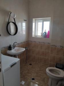 La salle de bains est pourvue d'un lavabo, de toilettes et d'une fenêtre. dans l'établissement Cozy Haven, à Bethléem
