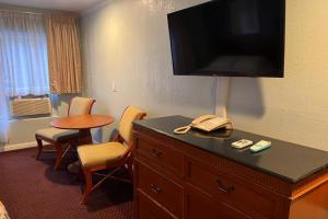 una habitación de hotel con un teléfono en la parte superior de una cómoda en The Islander Motel Santa Cruz, en Santa Cruz
