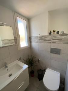 Un baño con un inodoro blanco y un lavabo. en Il Tramonto, en Roma