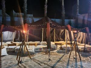 a tent with tables and chairs in the sand at La Maison des Vagues in Sidi Kaouki