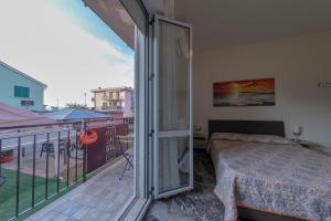 una camera da letto con balcone e letto di Affittacamere SS. Smile a Loreto