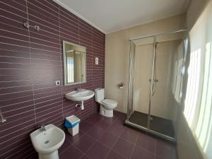 ein Badezimmer mit 2 WCs, einem Waschbecken und einer Dusche in der Unterkunft DON LEONE Hotel in Alginet