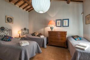 a bedroom with two beds and a dresser and a lamp at Luxury Villa Spoleto in Spoleto +20 photos