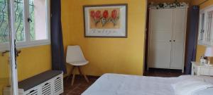 1 dormitorio con 1 cama y una pintura de flores en la pared en Sous les oliviers, en Tourrettes