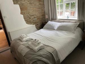 a bedroom with a bed with towels on it at Barlow Country Club - Mill Farm Cottages in Dronfield