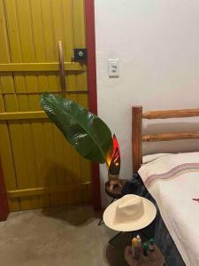 um quarto com uma cama, um chapéu e um candeeiro em chalé completo na fazenda em Bocaina de Minas