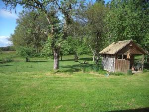 uma pequena cabana de madeira num campo com uma árvore em Espace Famille Montmillon em Chamblay