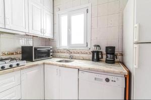 a white kitchen with a sink and a microwave at Luxury and comfortable flat in Ortakoy in Istanbul