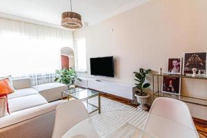 a living room with a white couch and a tv at Luxury and comfortable flat in Ortakoy in Istanbul