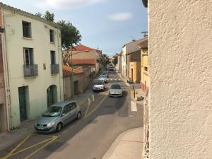 a city street with cars parked on the road at La casa Marcel, maison de 110 m2 in Pia