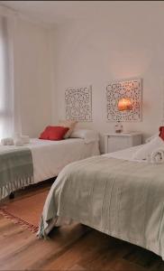two beds in a room with white walls at O Saramagal-Casa Nueva playa Area Brava - HIO in Hio