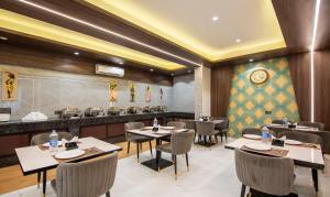 un restaurante con mesas y sillas y un bar en Treebo Trend The Armani, en Nueva Delhi