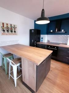 a kitchen with a large wooden table in a room at Le tie-break in Pont-Croix