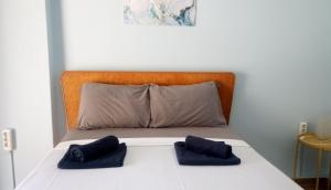 a bed with two blue pillows on top of it at Argiris Old City House 2 in Kalabaka
