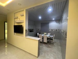 uma cozinha e sala de jantar com uma mesa e uma televisão em شقة كبيرة 3 غرف نوم وصالة Large apartment with 3 bedrooms and a living room em Taif