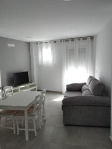 sala de estar con sofá y mesa en APARTAMENTOS TRES SOLES en Écija