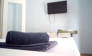a bedroom with a bed with a tv on the wall at Argiris Old City House 2 in Kalabaka