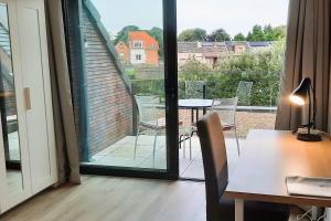 Habitación con mesa y vistas a un balcón. en BnB Waterzicht, en Wijnegem