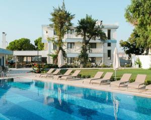a hotel swimming pool with lounge chairs and a building at Sığacık Gaea Hotel in Izmir