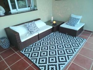 ein Wohnzimmer mit 2 Sofas und einem Teppich in der Unterkunft Habitación Atalaya in Olivella