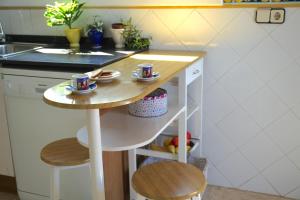eine kleine Küche mit einem Tisch und 2 Hockern in der Unterkunft Habitación Atalaya in Olivella