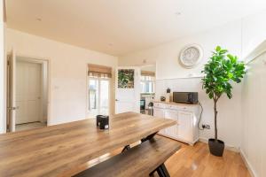 a dining room with a wooden table and a plant at Look No Further The Stable Block in Beautiful Beaufort House 2 Bedrooms in Bath