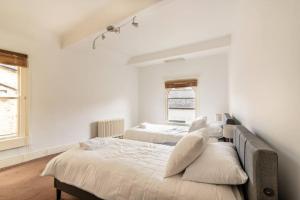 a bedroom with two beds and two windows at Look No Further The Stable Block in Beautiful Beaufort House 2 Bedrooms in Bath