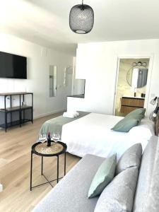 una habitación de hotel con dos camas y un sofá en Luxury views downtown, en Alicante