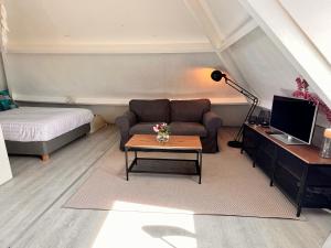 a living room with a couch and a table at Church Square Studio in Zandvoort