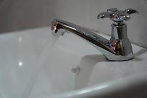 a silver faucet on a white bathroom sink at Taiping Modern Home in Kamunting