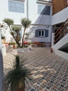 a courtyard with two potted plants and a house at La Maison des Vagues in Sidi Kaouki