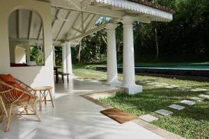 een paviljoen met stoelen en een tafel in de tuin bij Kara in Ahangama