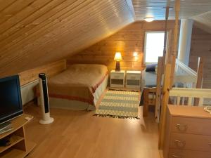 Kolinkylä的住宿－Saunaharju 5 järven rannalla，一间卧室配有一张床和一张书桌及电视